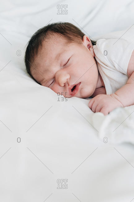 Cute newborn baby girl sleeping on bed in hospital