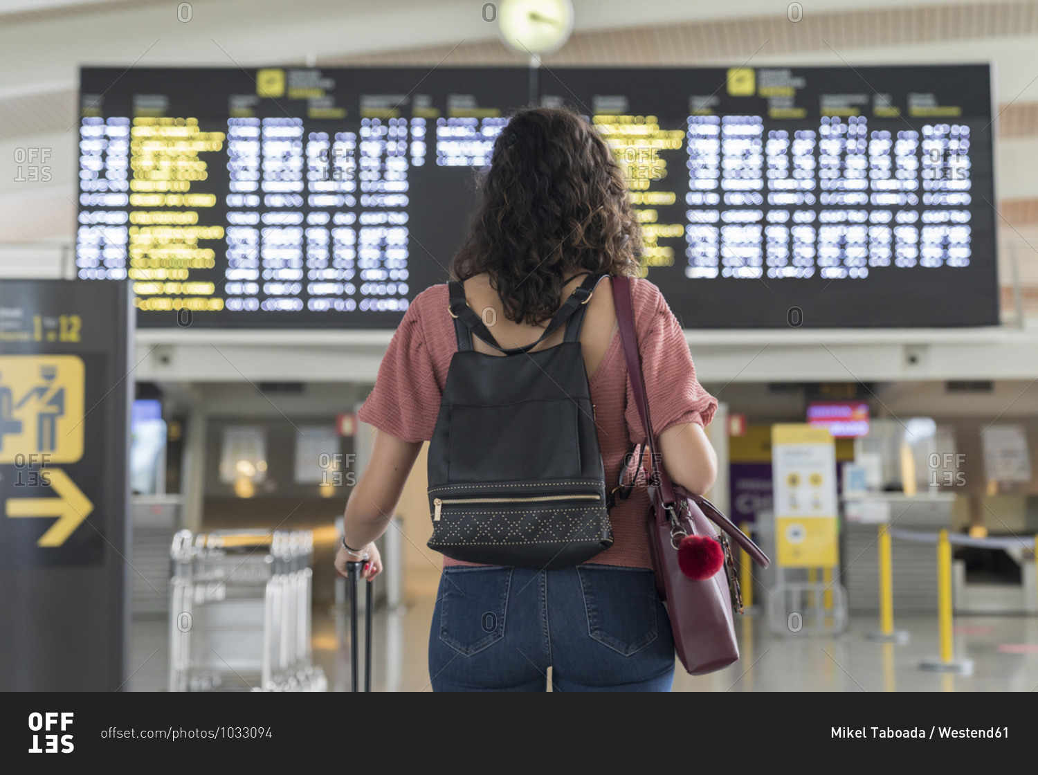 Young woman checking her flight in time board at airport