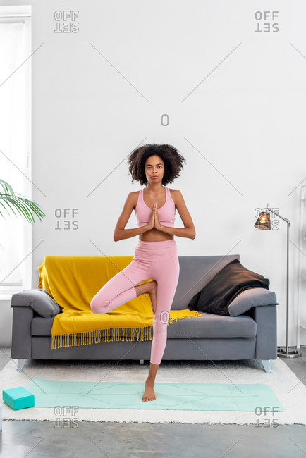 Fit Smiling Woman Practicing Tree Yoga Pose in Cozy Place Stock