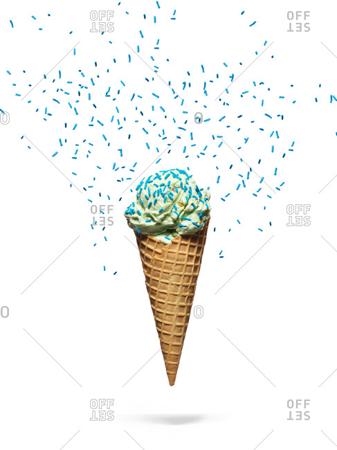 Ice cream cone floating on white background with sprinkles