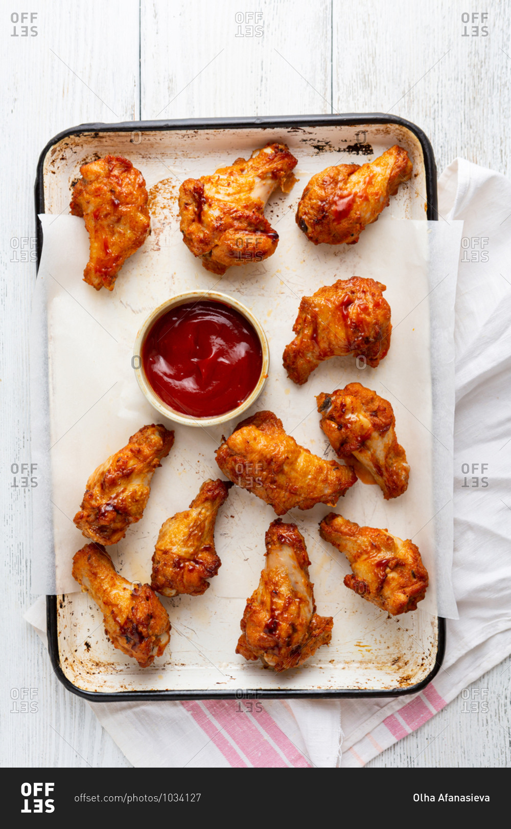 Chicken wings and sauce on baking sheet