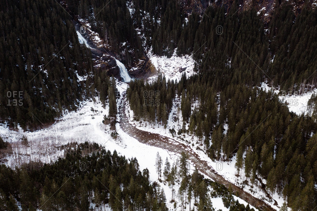 Drone view of amazing landscape of evergreen woods with frozen river in winter