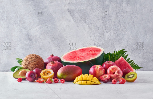 Set of assorted sweet exotic fruits and berries arranged on table in studio