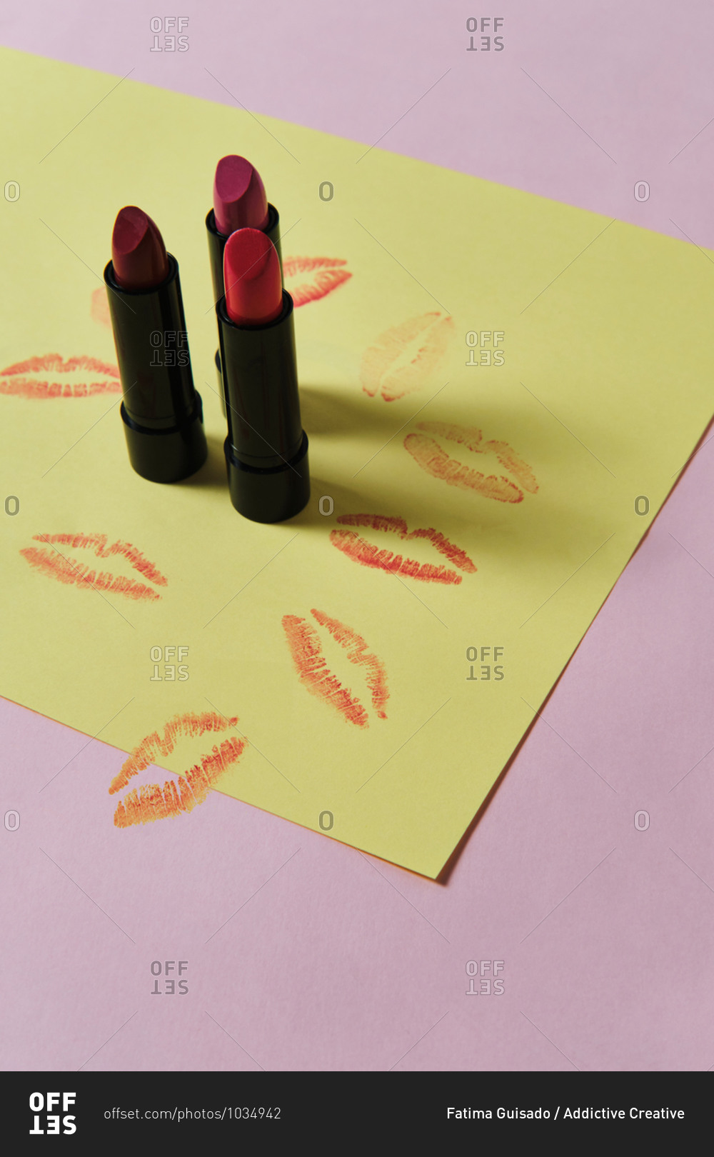 High angle of collection of luxury matte lipsticks placed on two colored background with kiss imprints