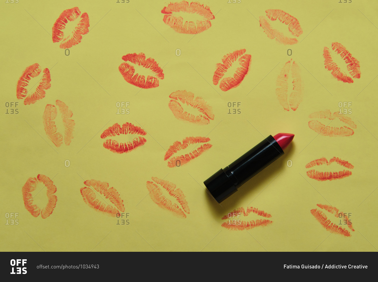 High angle of luxury matte lipstick placed on yellow background with kiss imprints