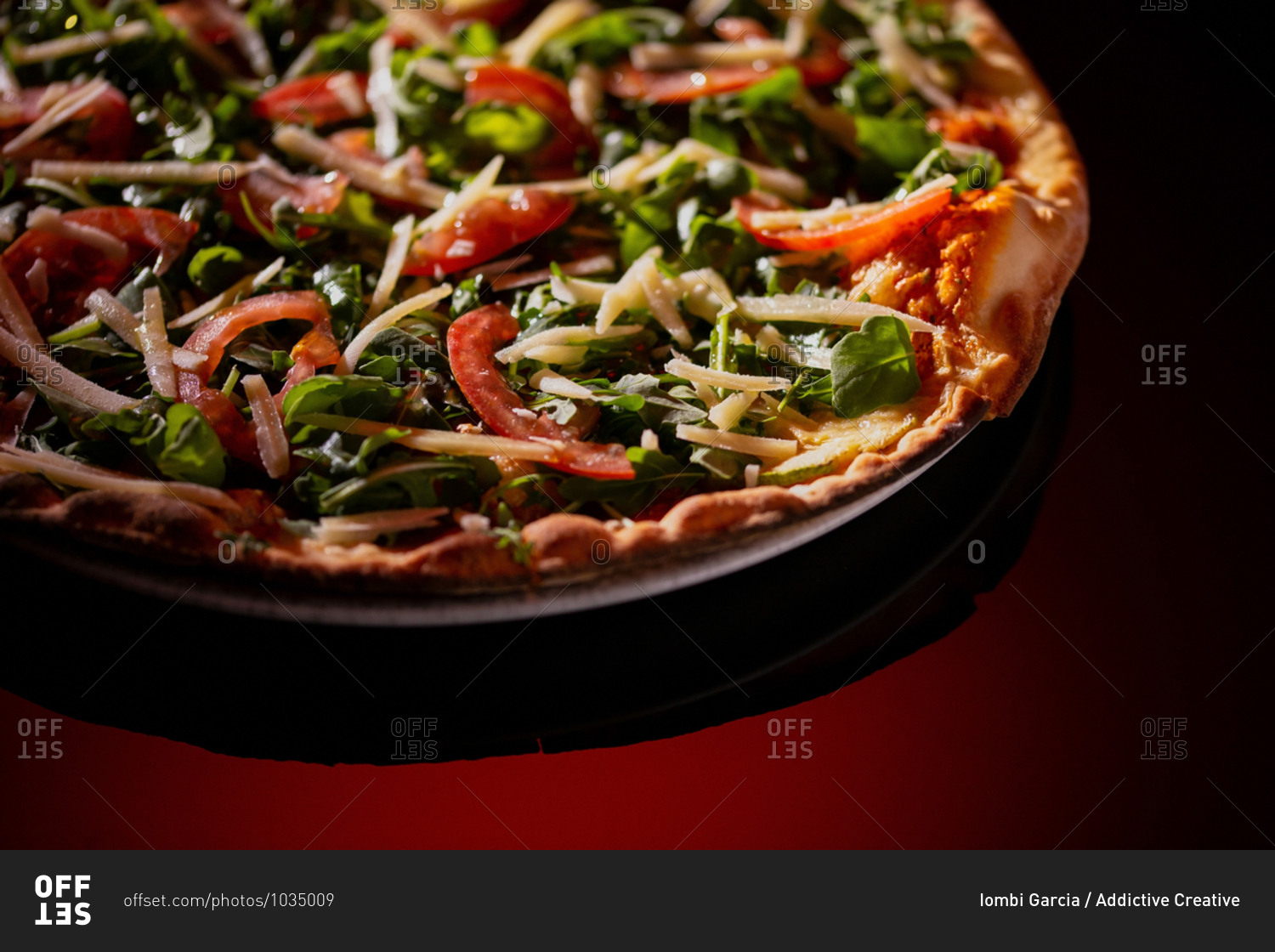 From above plate of tasty fresh pizza on dark red background