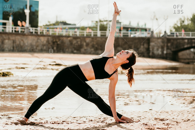 Woman doing standing yoga poses stock photo - OFFSET