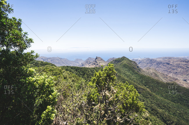 Breathtaking view of highland area with rocky mountains and green hills under blue sky in Tenerife