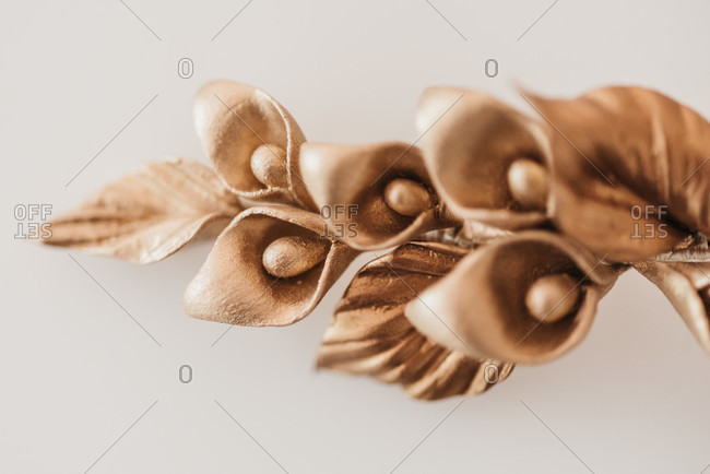 High angle of handmade hairpin with golden flowers and leaves placed on table in workshop