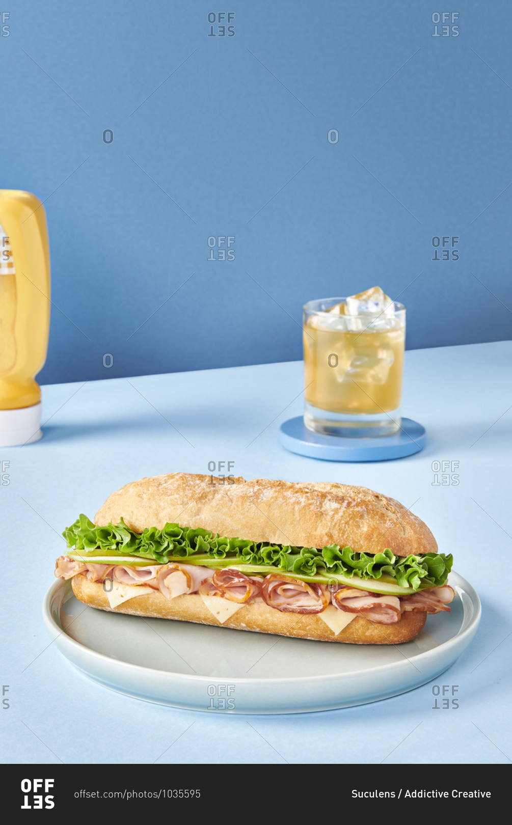 Appetizing sandwich with ham and fresh lettuce served on plate on table in cafeteria