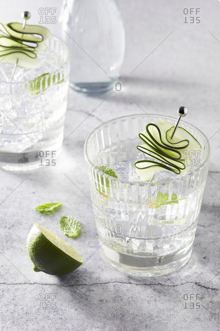 Refreshing Mojito cocktails in glasses with ice cubes arranged on table with lime slices