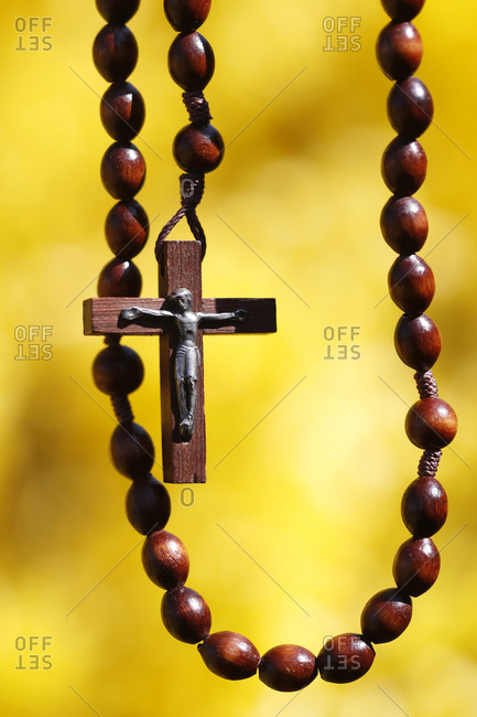 Wooden rosary against yellow broom flowers, France, Europe