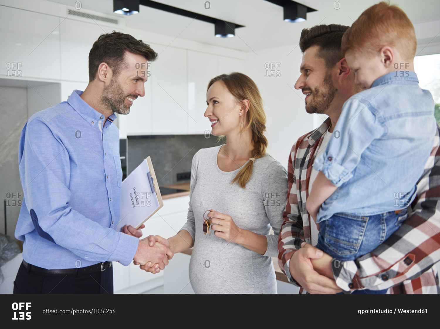 Family and real estate agent shaking hands in new apartment