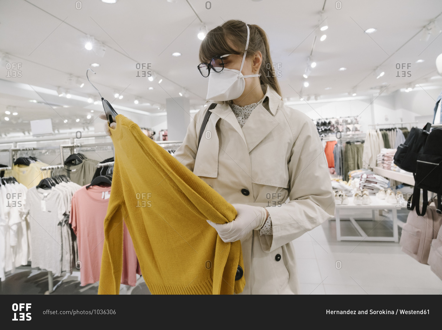 Woman with face mask and disposable gloves shopping in a fashion store