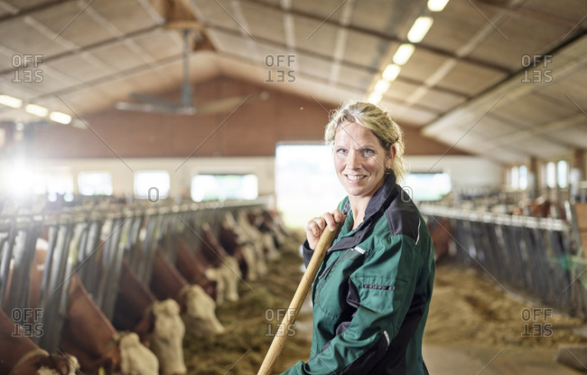Portrait of smiling female farmer in stable on a farm