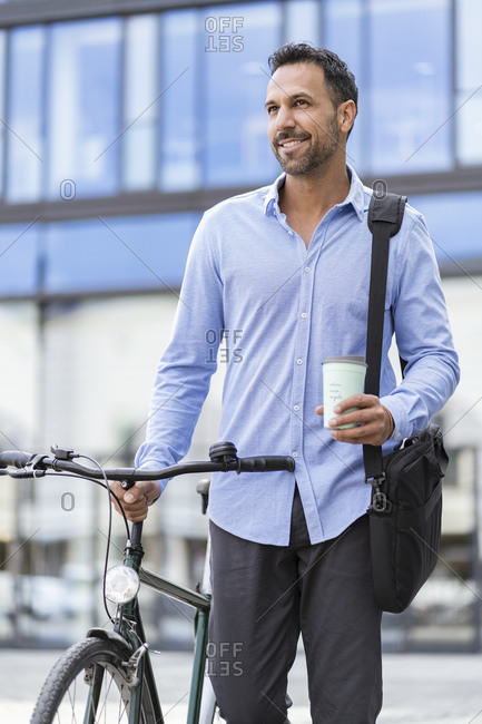 Businessman with bicycle on the go in the city