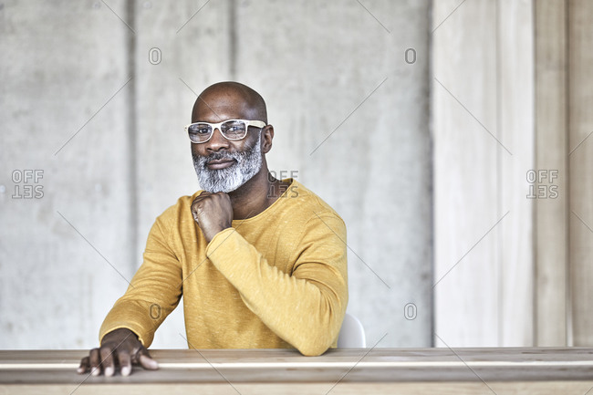 Portrait of confident mature businessman sitting at desk in office