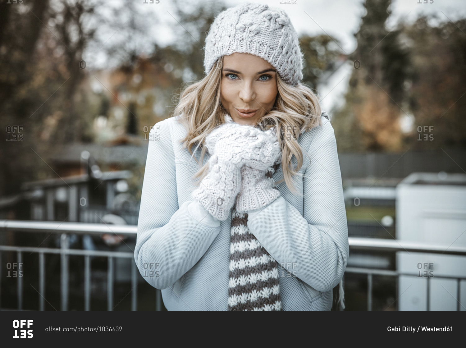 Portrait of smiling woman wearing woolly hat- gloves and scarf
