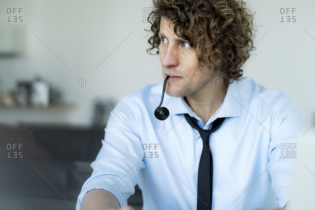 Easygoing businessman sitting in office- chewing sweets