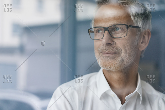 Successful manager looking out of window- thinking- portrait