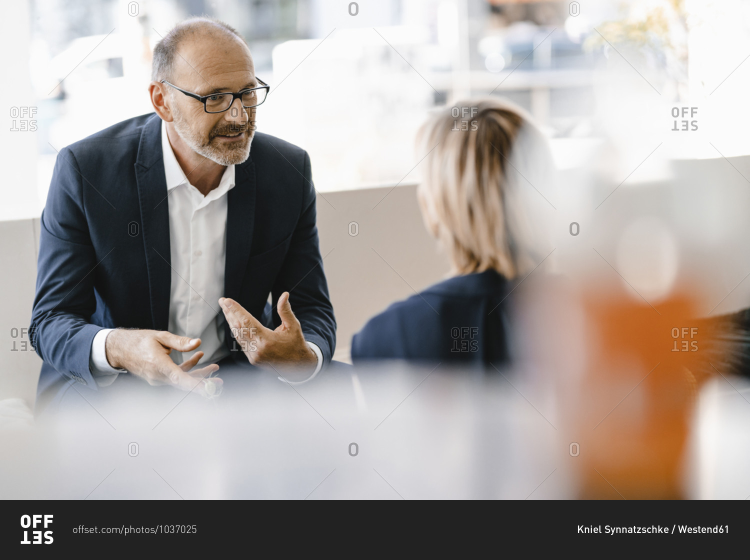 Businessman and woman having a meeting in a coffee shop- discussing work