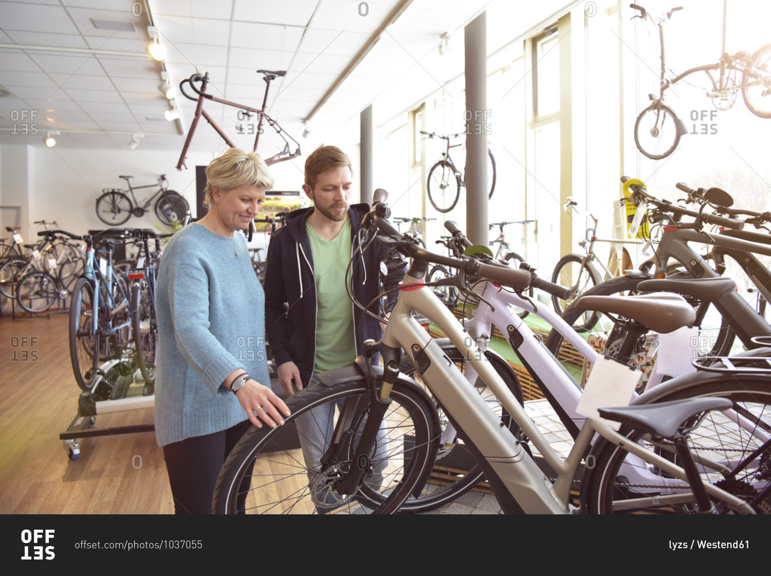 Salesman helping customer with e-bike