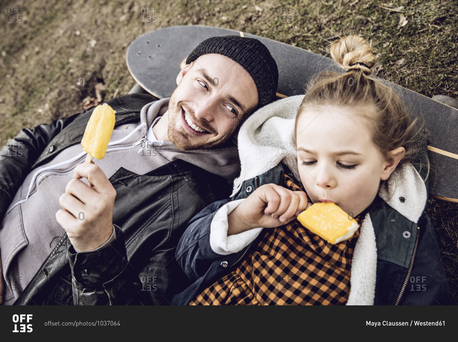 Father and daughter resting on skateboard- eating ice cream