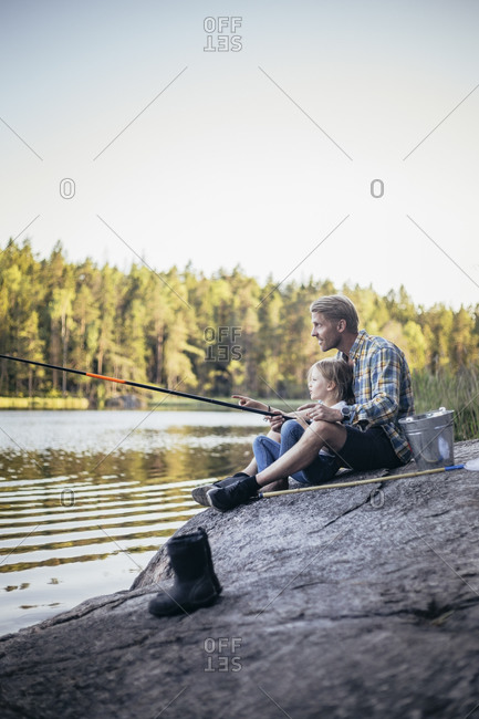 Father and daughter fishing at lake during weekend