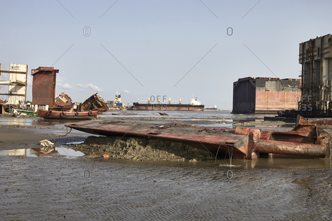Old ships and parts scattered in the mud at the Chittagong Ship Breaking Yards in Chittagong, Bangladesh
