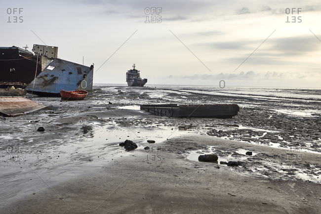 Large ships and ship parts scattered in the mud at the Chittagong Ship Breaking Yards in Chittagong, Bangladesh