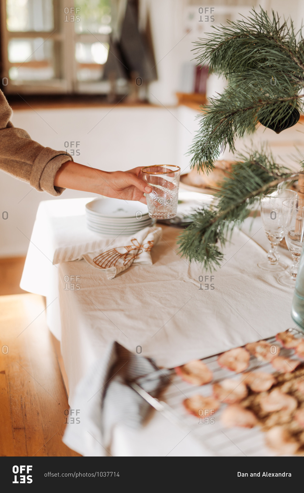 Woman placing glasses on a table being set for a holiday party