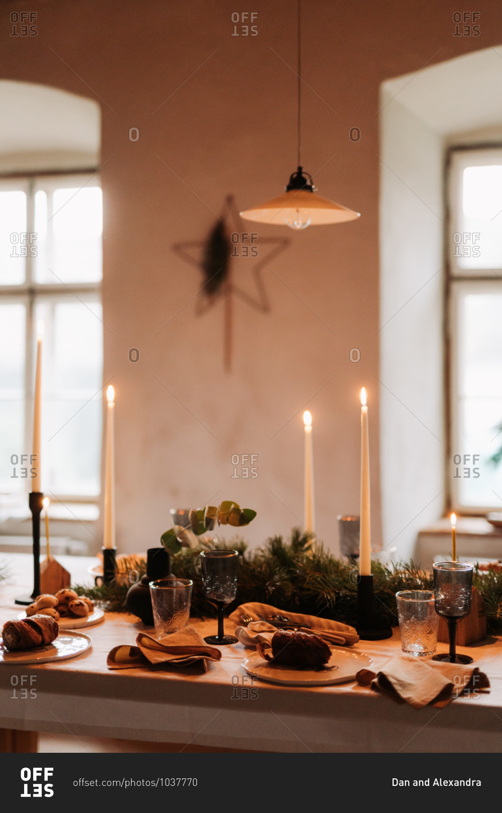 Christmas dinner gathering table with baked goods and lit candlesticks