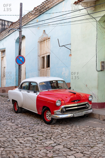 August 24, 2019: Street scene with an old American car on the cobblestone street. Trinidad, Cuba