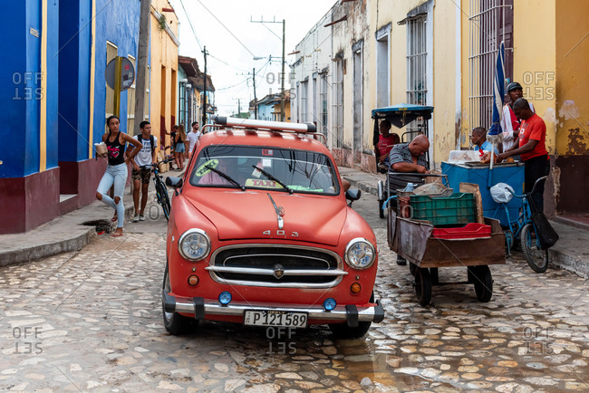 August 25, 2019: Street scene with an old American car on the cobblestone street. Trinidad, Cuba