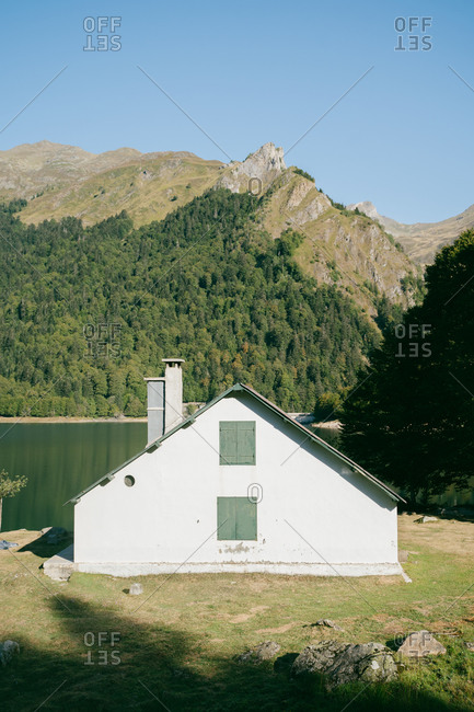 Small mountain hut next to a lake in French Pyrenees during a sunny morning