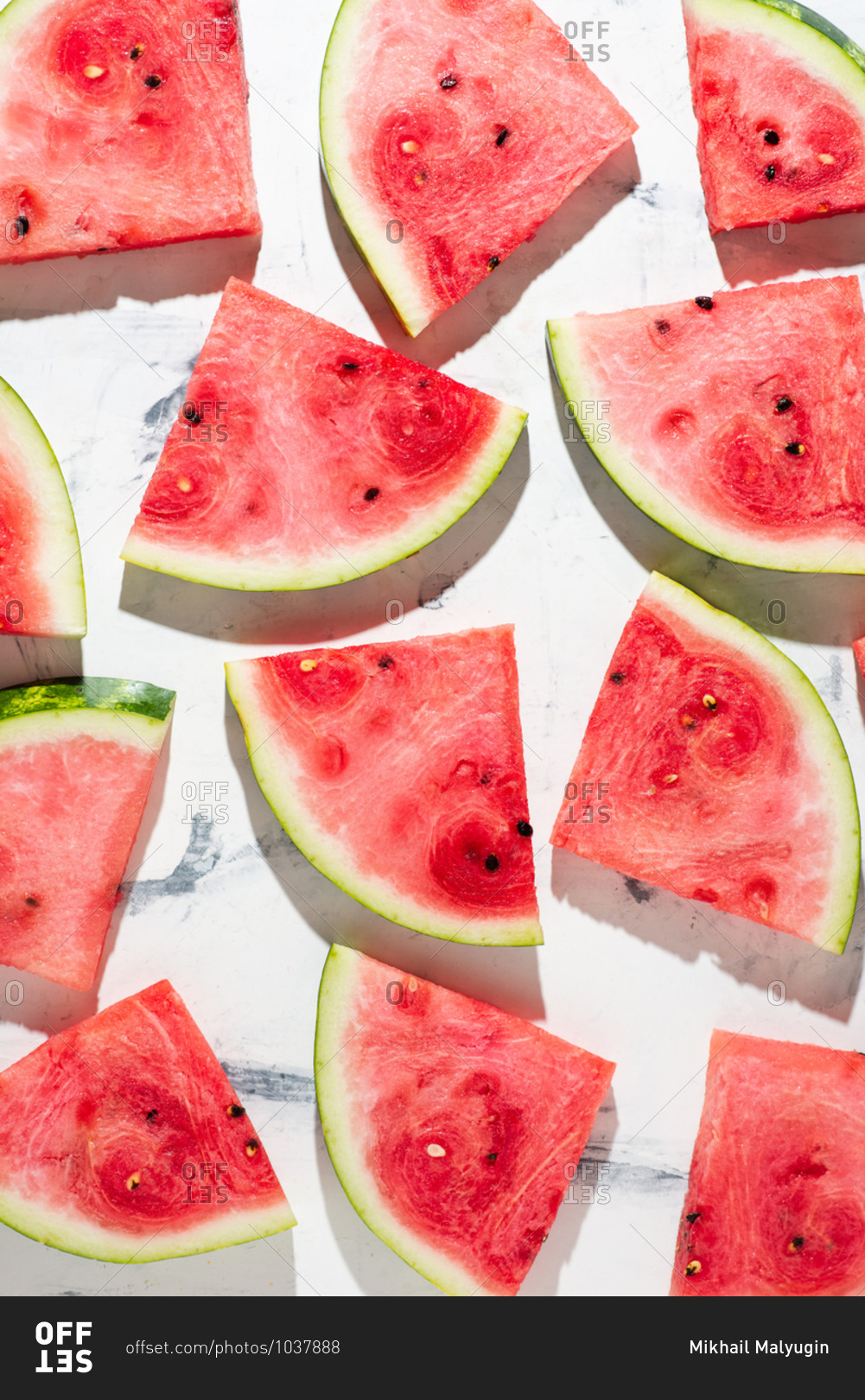 Overhead view of sliced watermelon served on white background