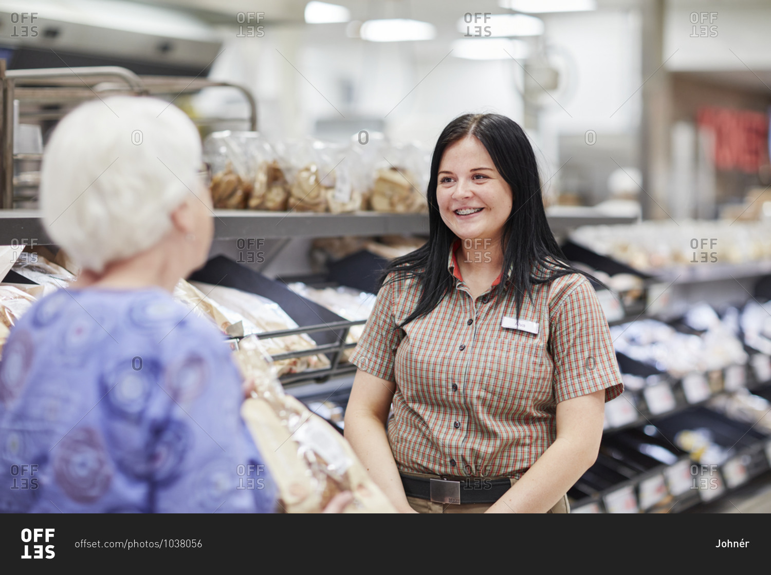 Woman in supermarket talking to store clerk