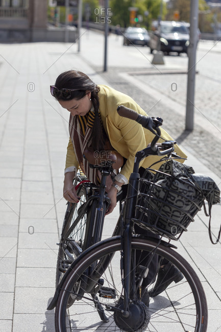 Woman locking bicycle. Detailed shot.