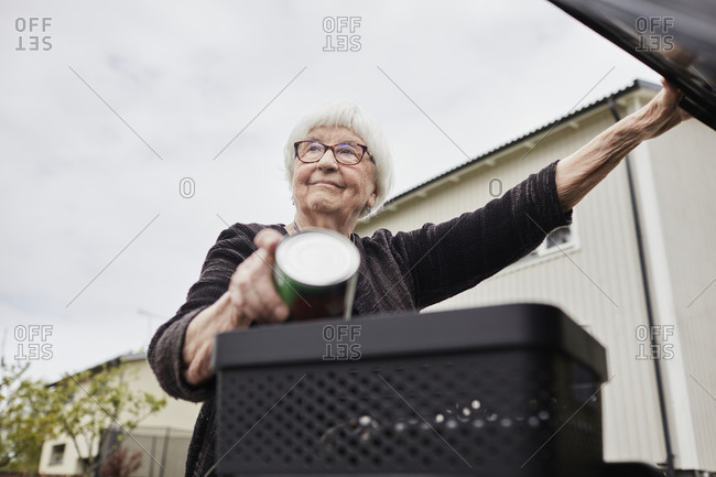 Woman putting rubbish into bin. Detailed shot.