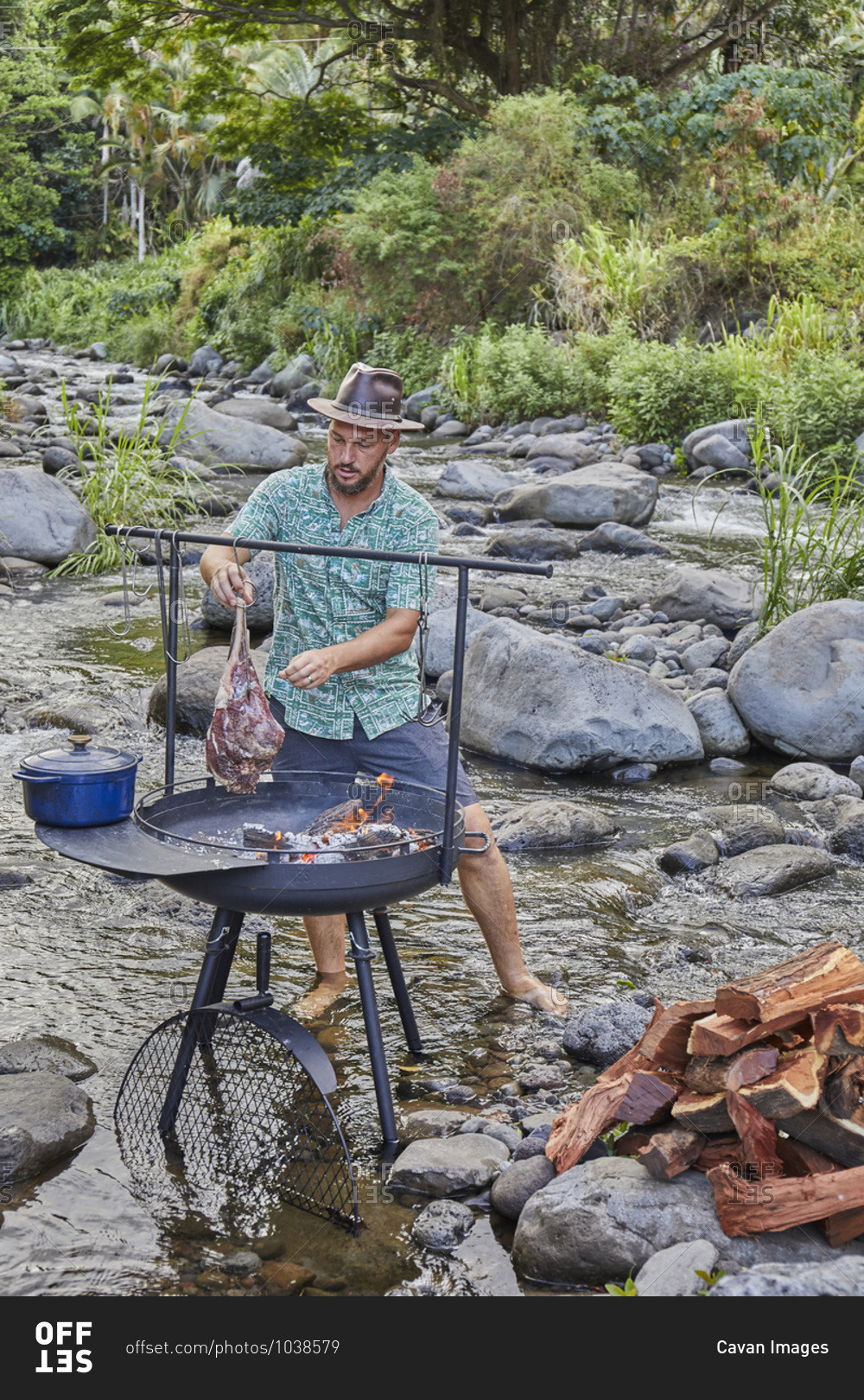 Chef Cooking over Open Fire at Campsite near Streambed
