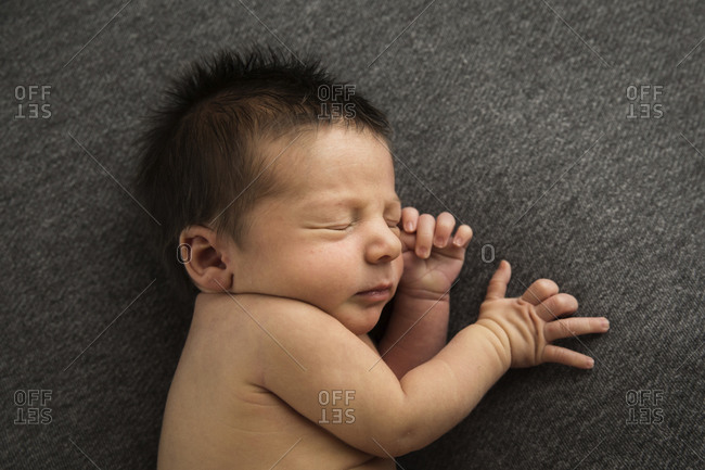 Newborn baby boy sleeping on a blanket stock photo - OFFSET