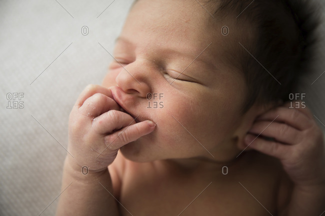 Close Up of Detail, Newborn Baby With Lots of Hair Sucking His Fingers