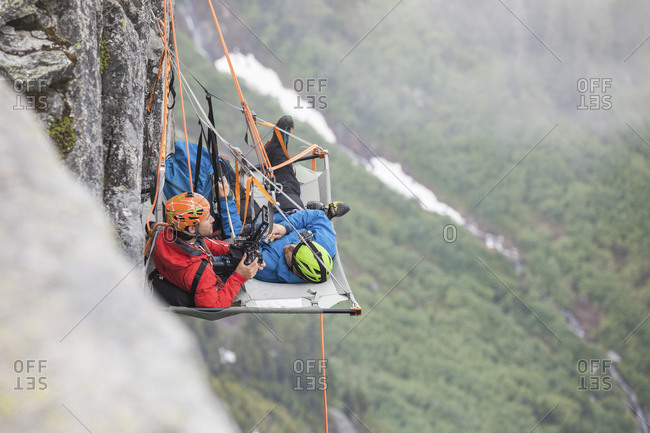 Rock climbers rest on a portaledge during a multi-day climbing trip.