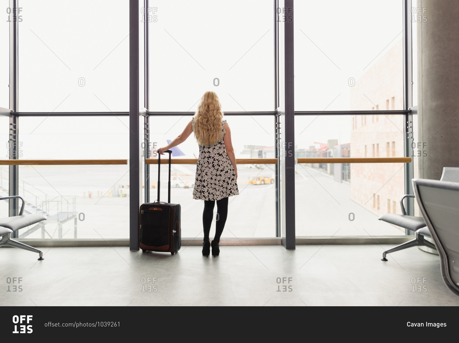 Female traveler with luggage standing in airport
