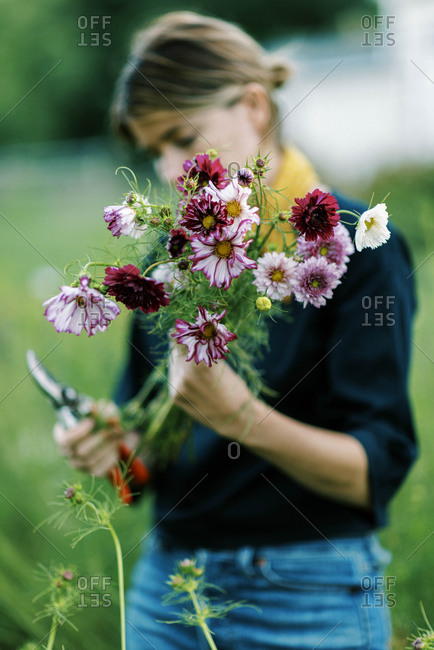 Millennial woman working at her flower farm making bouquets