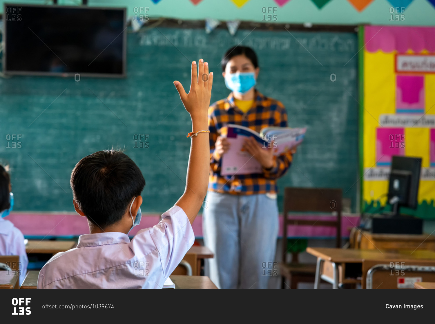Students and her teacher wearing protective face masks in classroom