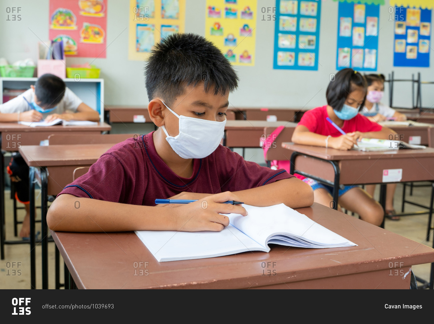 Elementary school students wearing masks study in classroom