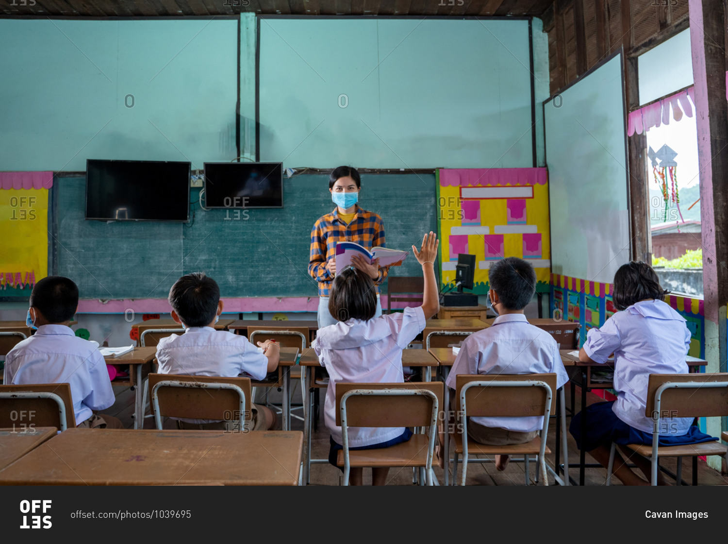 Asian children wear face masks while learning in classroom
