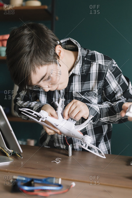 Boy making drone on table at home