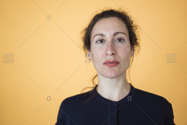 Close-up of female entrepreneur against orange wall